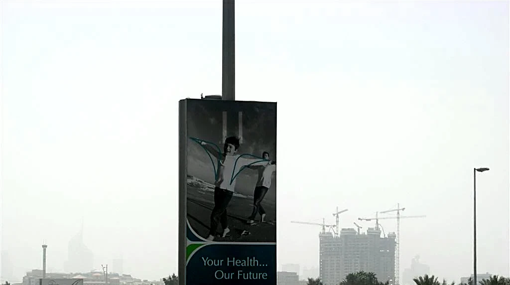 A lamp-post banner: the boy on the beach in black and white, with the line Your Health, Our Future.