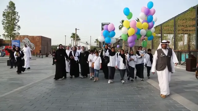 Students and families walking with balloons along the waterfront
