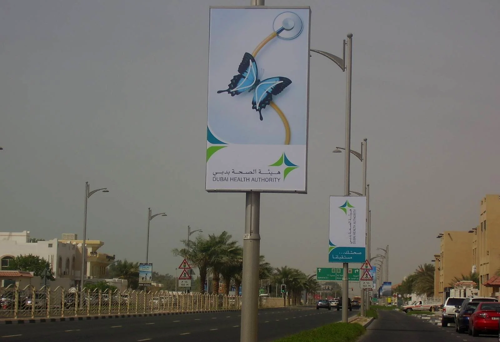 Jumeirah Beach Road, Dubai, April 2008: a lamp-post light box with the butterfly in colour and the Dubai Health Authority logo