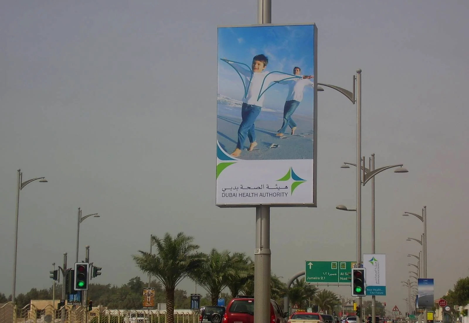 Jumeirah Beach Road, Dubai, April 2008: a lamp-post light box with the two boys in colour and the Dubai Health Authority logo